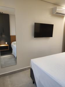 a bedroom with two beds and a tv on the wall at Salinas Premium Resort in Salinópolis +25 photos