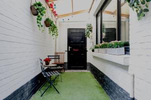a patio with a black door and a table and chairs at JT HOMES in Bruges