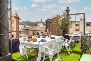 - Balcón con mesa blanca y sillas en II-II Hub Luxury New Apartments en Barcelona