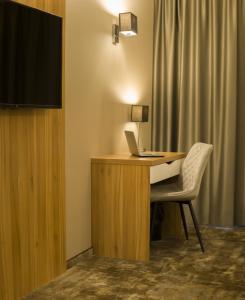 einen Schreibtisch mit einem Laptop und einem Stuhl in einem Zimmer in der Unterkunft Baltic Plaza Hotel Medi Spa in Kołobrzeg