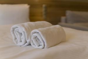 una pila de toallas sentadas encima de una cama en Baltic Plaza Hotel Medi Spa, en Kołobrzeg