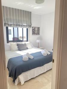 1 dormitorio con 1 cama grande y toallas. en Homey Home Guadalvillas 91 en Marbella