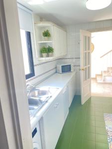 cocina con armarios blancos, fregadero y ventana en Homey Home Guadalvillas 91, en Marbella