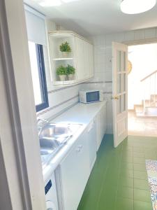 kuchnia z białymi szafkami, zlewem i oknem w obiekcie Homey Home Guadalvillas 91 w Marbelli