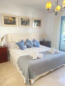 sypialnia z dużym łóżkiem z niebiesko-białymi poduszkami w obiekcie Homey Home Guadalvillas 91 w Marbelli