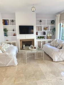 un soggiorno con 2 divani e una TV di Homey Home Guadalvillas 91 a Marbella