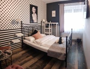 um quarto com uma cama preta e branca num quarto em Stőger Panzió em Vasszécseny