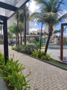 a courtyard with palm trees and a walkway at Salinas Premium Resort in Salinópolis