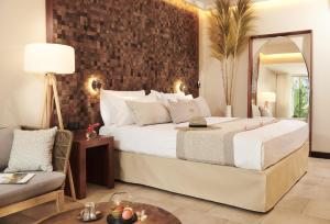 una camera d'albergo con un grande letto e una sedia di Palm Hotel & Spa a Petite-Île