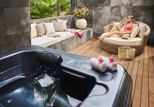 une femme assise sur une chaise dans une fontaine dans l'établissement Palm Hotel & Spa, à Petite Île