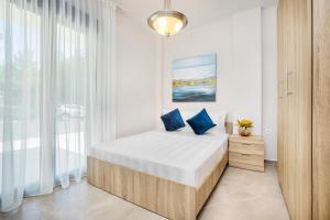 Un dormitorio con una cama con almohadas azules. en Epta Villas Luxury Redefined en Agia Paraskevi