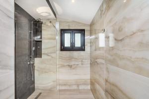 baño con ducha y puerta de cristal en Epta Villas Luxury Redefined en Agia Paraskevi