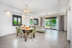 comedor y sala de estar con mesa y sillas en Epta Villas Luxury Redefined en Agia Paraskevi