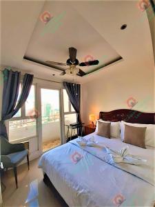 Schlafzimmer mit einem Bett und einem Deckenventilator in der Unterkunft Birch Tower Studio Condo - Staycation in Manila in Manila
