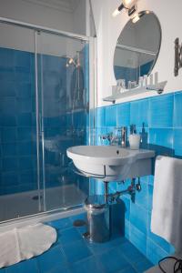 y baño azul con lavabo y ducha. en Affittacamere Capri Dolce Vita en Capri