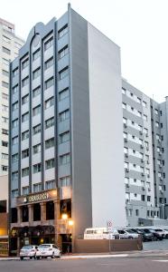 een groot gebouw met auto's geparkeerd voor het bij Bourbon Londrina Business Hotel in Londrina