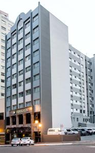 a large building with cars parked in front of it at Bourbon Londrina Business Hotel in Londrina