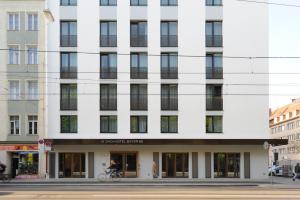 un bâtiment blanc au coin d'une rue dans l'établissement Bayer 89 Vi Vadi Hotel, à Munich