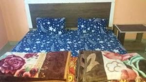 a bed with two books sitting on top of it at SPOT ON Sharma's Kitchen & Home Stay in Bajaura