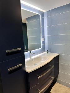 a bathroom with a sink and a mirror at L'Opale - Le Jungle in Les Attaques