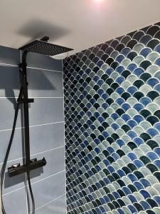 a bathroom with a blue and white tiled wall at L'Opale - Le Jungle in Les Attaques