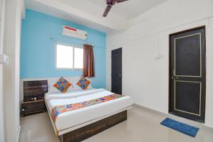 a bedroom with a bed and a blue wall at Via Diamond Inn in Pune