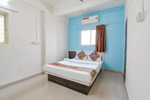 a small bedroom with a blue accent wall at FabExpress Diamond Inn in Pune