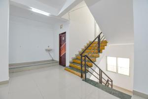 a staircase in a room with white walls and white floors at FabExpress Diamond Inn in Pune +16 photos