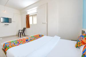 a bedroom with two beds and a tv at FabExpress Diamond Inn in Pune