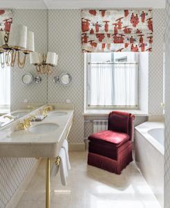 a bathroom with a sink and a tub and a chair at NARUTIS hotel in Vilnius