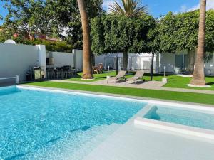 una piscina en un patio con palmeras en Malibú Ocean Villa, en Santa Cruz de Tenerife