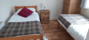 1 dormitorio con 2 camas individuales y mesita de noche en Newmarket en Stornoway