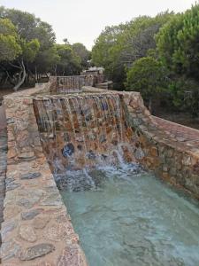 a large waterfall in a stone wall with water at Vista al Mar with Parking Space in La Mata