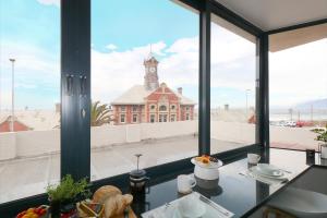 a view of a building with a clock tower from a window at South Surf Apartment in Muizenberg