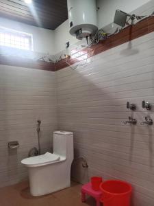 baño con aseo blanco en una habitación en The Spotted Dove Homestay, en Maneri