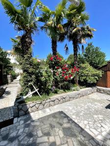 un passaggio in pietra con palme e fiori di Apartments Miro a Ičići
