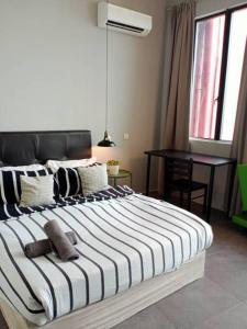 ein Schlafzimmer mit einem großen Bett mit einer schwarzen und weißen Decke in der Unterkunft Eternally Studio Empire Damansara/Wi fi/Netflix in Petaling Jaya