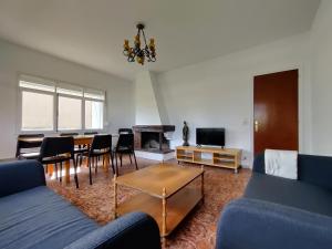 Una sala de estar con un sofá azul y una mesa. en Casa A Mariña, en Barreiros