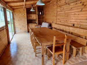 a dining room with a wooden table and chairs at Casa A Mariña in Barreiros