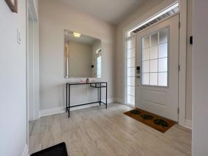 um corredor com uma porta, uma mesa e um espelho em GLOBALSTAY New houses near Huron Lake em Port Elgin