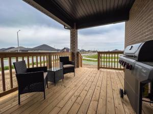 um deque com cadeiras, uma mesa e um grelhador em GLOBALSTAY New houses near Huron Lake em Port Elgin