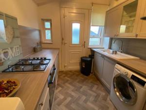a kitchen with a stove top oven next to a sink at Glasgow excellent lodging home in Glasgow
