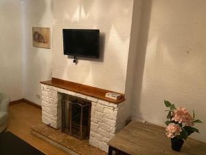 a living room with a fireplace with a flat screen tv at Glasgow excellent lodging home in Glasgow