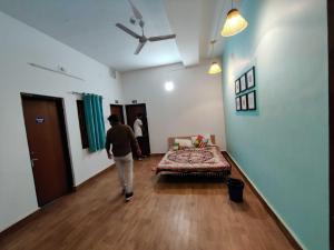 una persona caminando por una habitación con cama en Housefull Residency, en Khandagiri