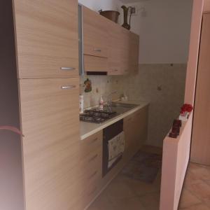 a kitchen with wooden cabinets and a sink and a stove at Barbara Meniconi in Città della Pieve