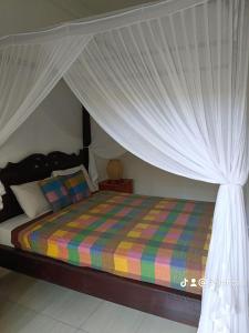 a bedroom with a bed with a canopy at Lumbung Sari Home Stay in Amed