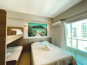 een slaapkamer met 2 bedden en een groot raam bij Pousada La Acolhida in Cabo Frio