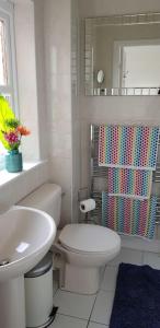 bagno bianco con servizi igienici e lavandino di Home2Home Meadow House a East Kilbride