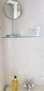 un espejo sobre un estante sobre un lavabo en Home2Home Meadow House en East Kilbride