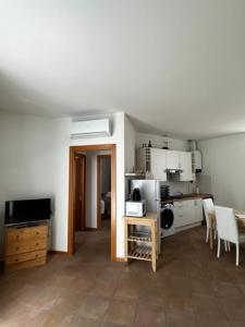 a kitchen with white cabinets and a table with chairs at Casa Sole in Varenna +18 photos